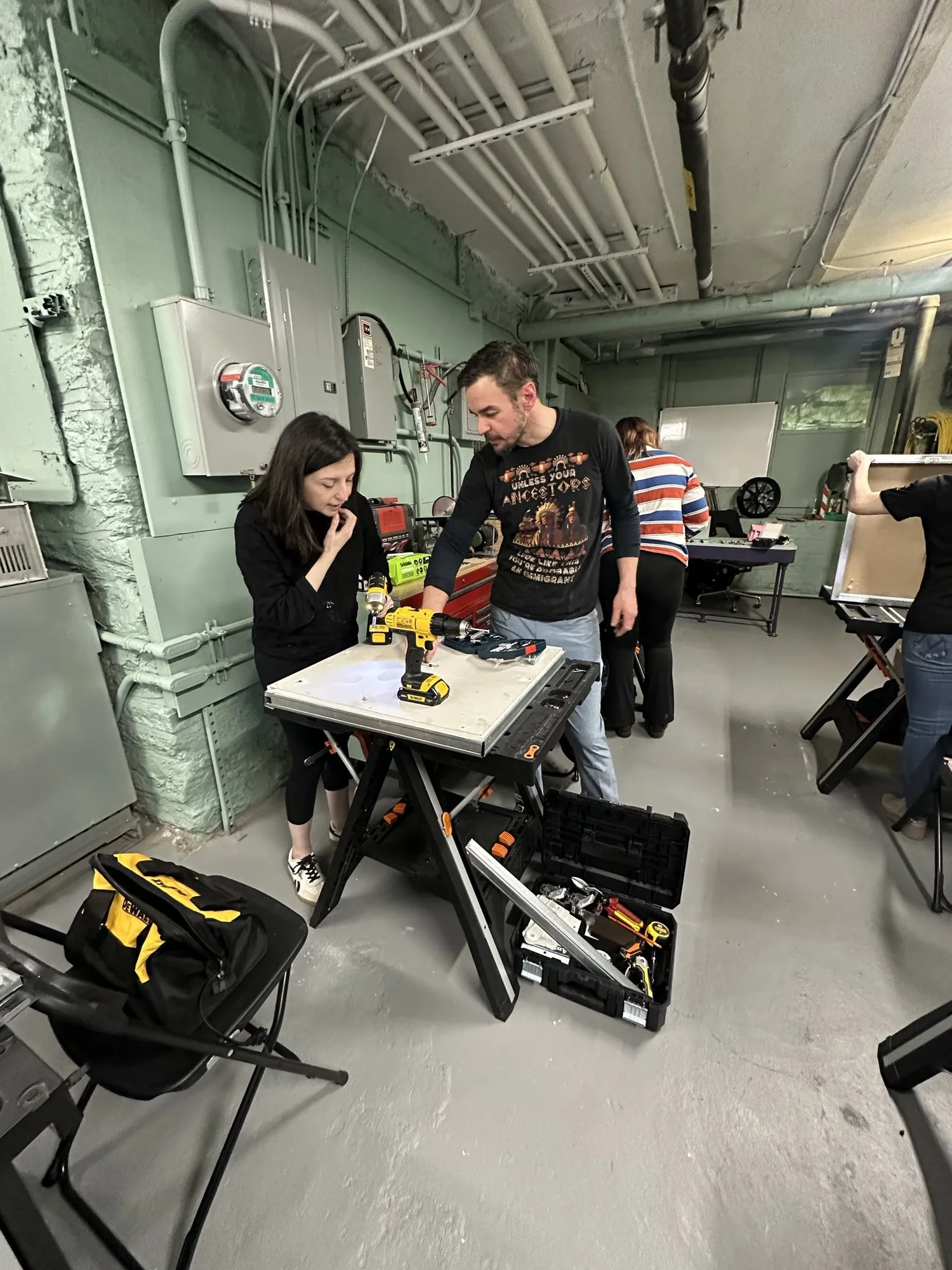 An instructor and a student working with a power drill at a Back to Basics workshop